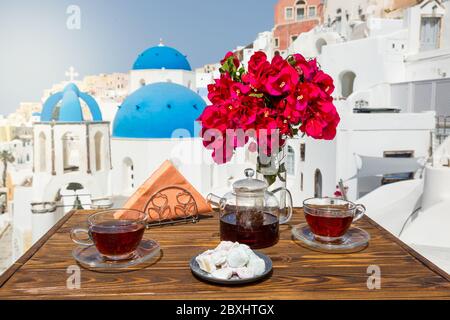 Tee und Süßigkeiten auf dem Tisch am Strand von Santorini Stockfoto