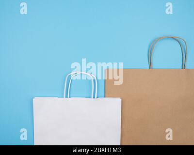 Weiß und braun Papier Einkaufstaschen auf blauem Hintergrund. Stockfoto