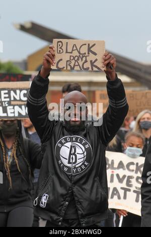 Ein Protestler, der ein Plakat hält, marschiert auf der Vauxhall Bridge in Richtung Whitehall während der Demonstration.der Tod von George Floyd, während in der Obhut der Minneapolis-Polizei hat Proteste in den Vereinigten Staaten sowie Demonstrationen der Solidarität auf der ganzen Welt ausgelöst. Stockfoto