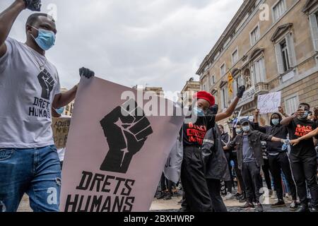 Zwei Protestierende halten ein Plakat zur Verteidigung der Menschenrechte während der Demonstration.als Folge des Todes von George Floyd, während er von der Minneapolis Polizei, Minnesota, festgehalten wurde, demonstrieren Tausende von Menschen in Barcelona gegen Rassismus. Stockfoto
