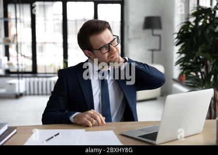 Unwell Geschäftsmann leiden an Rückenschmerzen im Büro Stockfoto
