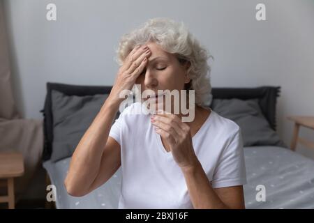 Ungesunde ältere Frau leiden an Migräne zu Hause Stockfoto