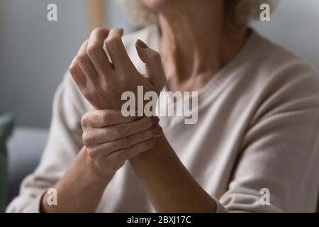 Nahaufnahme einer älteren Frau, die den Puls am Handgelenk überprüft Stockfoto