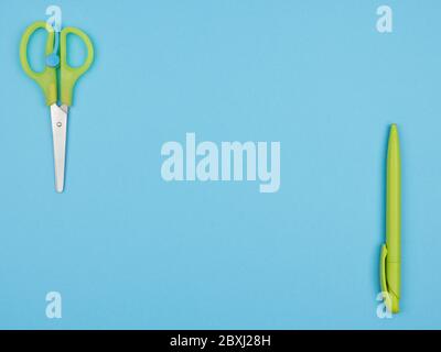Schere und Stift auf blauem Hintergrund. Stockfoto
