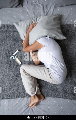 Draufsicht auf kranke reife Frau im Bett liegend leiden Stockfoto
