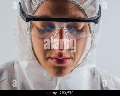 Schutz vor ansteckenden Krankheiten, Coronavirus. Weibliche Arzt trägt chirurgische hygienische Gesicht medizinische Maske. Müder Wissenschaftler. Studio Foto, weiß e Stockfoto