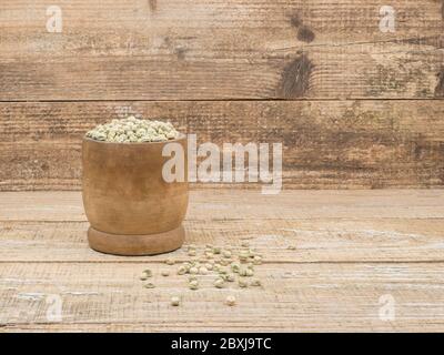 Trockene Erbsenkörner für die Bepflanzung im Boden auf Holzgrund. Stockfoto