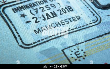 Einreisestempel im Reisepass, der von einem Einwanderungsbeamten an der Grenze und der Visumkontrolle am Flughafen Manchester in Großbritannien gemacht wurde. Selektiver Fokus. Makrofoto. Stockfoto