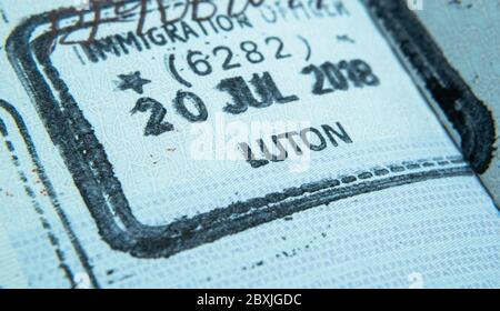 Einreisestempel im Reisepass, der von einem Einwanderungsbeamten an der Grenze und der Visumkontrolle am Flughafen Luton in Großbritannien gemacht wurde. Selektiver Fokus. Makrofoto. Stockfoto