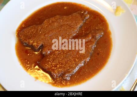 Geschmorte Fleischscheiben in der Schüssel mit Sauce Stockfoto