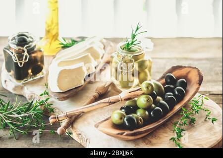 Oliven sind grn und schwarz mit Weichkse mit Schimmel wie Brie, Camembert  mit Olivenl und Thymian. Kse und Oliven in einem Olivenbaum Gericht  Stockfotografie - Alamy