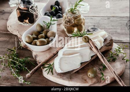 Oliven sind grn und schwarz mit Weichkse mit Schimmel wie Brie, Camembert  mit Olivenl und Thymian. Kse und Oliven in einem Olivenbaum Gericht  Stockfotografie - Alamy