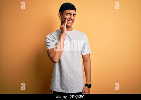 Gut aussehend afroamerikanischen Sportler tun Sport tragen Sportbekleidung über gelben Hintergrund berühren Mund mit der Hand mit schmerzhaften Ausdruck wegen Stockfoto