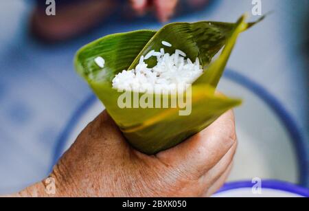 Hand halten Blatt gefüllt mit klebrigem Reis zu Zong zi, die traditionellen chinesischen Reisknödel für Drachenboot Festivals zu machen. Stockfoto