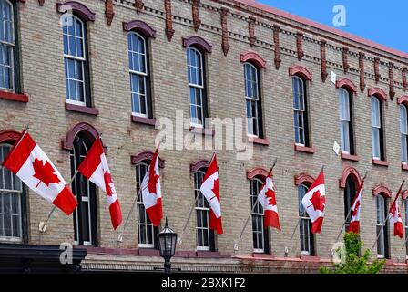 Altes Gebäude mit einer Reihe von kanadischen roten und weißen Ahornblattfahnen Stockfoto