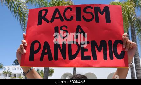 Oceanside, CA / USA - 7. Juni 2020: Frau hält ein Schild mit der Aufschrift "No Justice, No Peace" während des protestmarsches von Black Lives Matter hoch. Stockfoto