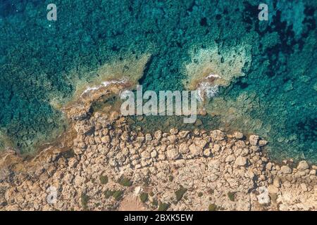 Meeresansicht von oben, azurblaues Wasser mit felsiger Küste in Zypern, mediterrane Landschaft von oben.