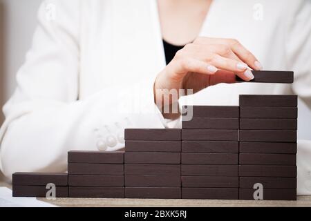 Geschäftskonzept, Frauenhände bilden Holzwürfel, die den Erfolg des Unternehmens symbolisieren Stockfoto