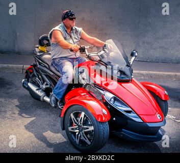 Ein weißer Biker auf drei Rädern, mit einem Bandana auf einem BRP Can-am Spyder Trike, in St. Cloud, MN, USA Stockfoto