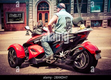 Rückansicht eines weißen Biker auf drei Rädern, der ein Bandana auf einem BRP CAN-am Spyder Trike in St. Cloud, MN, USA trägt Stockfoto