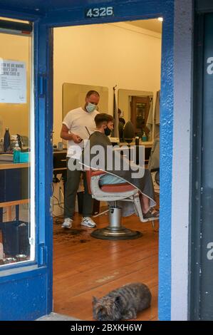 Vancouver, Kanada. Juni 2020. Ein Kunde, der auf einem Friseurstuhl sitzt, erhält einen Haarschnitt, da die Beschränkungen aufgehoben werden und Friseurläden und Friseursalons während der COVID 19-Pandemie wieder geöffnet werden. Stockfoto