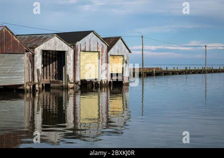 Bootshäuser spiegeln sich im Wasser. Aufnahme auf dem Eriesee in Port Rowan, Ontario. Stockfoto