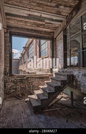 HDR-Bild der verlassenen (jetzt abgerissenen) Scranton Lace Factory in Scranton, Pennsylvania. Bild zeigt die Backstein außen und innen Holztreppe Stockfoto