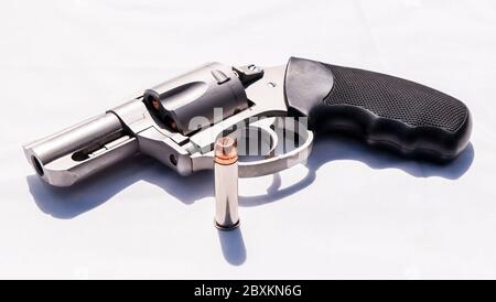 Ein Edelstahl-Snub-Nosed 357 Magnum Revolver mit einem hohlen Punkt Kugel daneben auf weißem Hintergrund Stockfoto