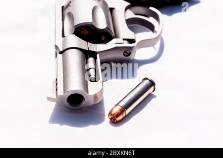 Ein Edelstahl-Snub-Nosed 357 Magnum Revolver mit einem hohlen Punkt Kugel daneben auf weißem Hintergrund Stockfoto