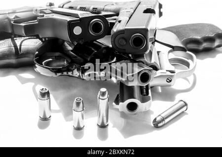 Vier Handfeuerwaffen, zwei Revolver, ein Kaliber 38 und ein Magnum 357 und zwei Pistolen, ein 9mm und ein vierzig Kaliber auf weißem Hintergrund Stockfoto