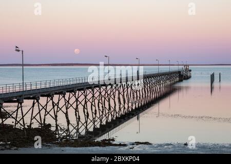 Der Mond und Pier in Ceduna in Südaustralien bei Sonnenaufgang Stockfoto