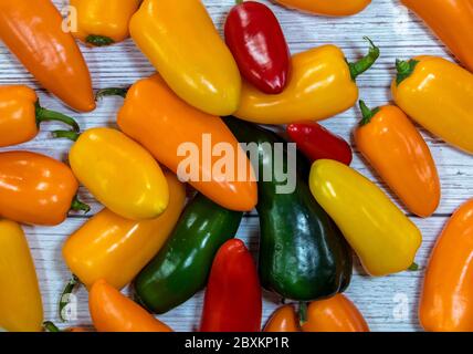 Eine Gruppe von ganzen frischen Paprika flach auf einem hölzernen Hintergrund Stockfoto