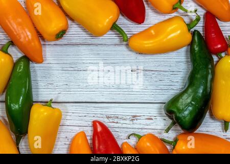 Eine Gruppe von ganzen frischen Paprika flach auf einem hölzernen Hintergrund Stockfoto