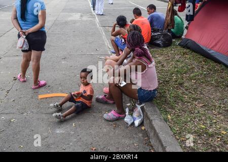 Gestrandete Venezolaner bauen ein provisorisch behelfsmäßiges Lager in einem baumbestandenen Park inmitten der Covid-19-Pandemie und warten auf die Möglichkeit, in ihr Land, Cali, Stockfoto