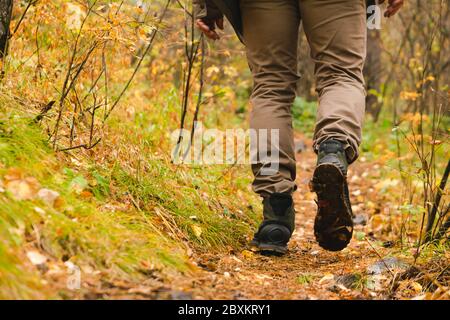 Ein Mann Reisende Spaziergänge entlang Waldweg in Wanderschuhen. Tourismus und Abenteuer Konzept. Horizontaler Rahmen Stockfoto
