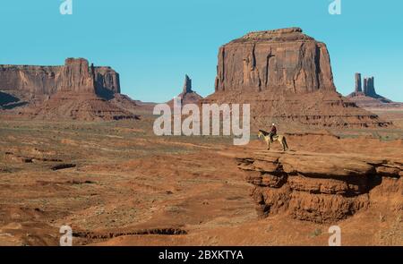 Ein Mann auf dem Pferderücken blickt auf John Ford's Point in Monument Valley, Arizona Stockfoto