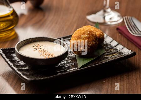 Gebratene Bälle arancini gefüllt mit Käse und frittiert mit Sauce auf einem verschwommenen Hintergrund thai-Essen Stockfoto