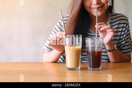 Nahaufnahme Bild von einer schönen asiatischen Frau trinken Eiskaffee mit Edelstahl Stroh Stockfoto