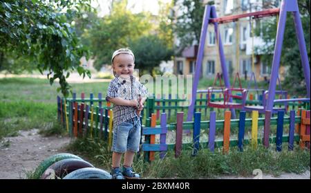 Das Baby zeigt Emotionen. Das Baby lacht, lächelt. Das Kind spielt auf dem Spielplatz. Stockfoto