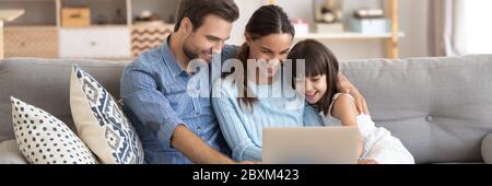Paar und kleine Tochter mit Computer-Cartoons online beobachten Stockfoto