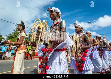 Coconut Flower Tänzer treten entlang der Küstenstraße während der buddhistischen perahera (Prozession) in Hikkaduwa in Sri Lanka auf. Stockfoto