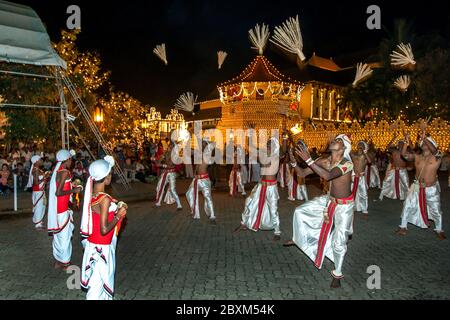 Coconut Flower Tänzer treten vor dem Tempel des Heiligen Zahnrelikas während der Esala Perahera in Kandy in Sri Lanka auf. Stockfoto