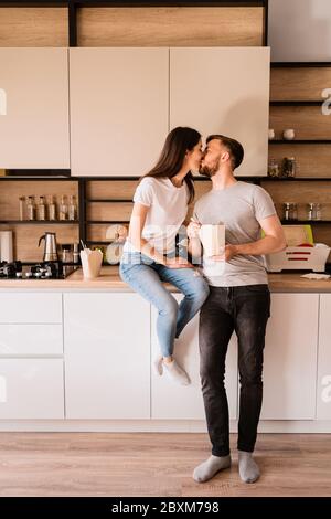 Küssen junge Paar hat eine gute Zeit zusammen zu Hause beim Essen chinesisches Essen Stockfoto