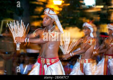 Coconut Flower Tänzer treten auf den Straßen von Kandy während der Esala Perahara in Sri Lanka auf. Die Kokosblüte wird als Symbol des Wohlstands gesehen. Stockfoto