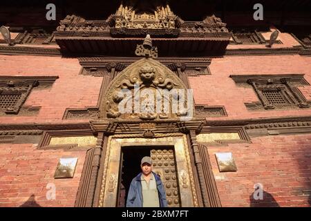 Ein nepalesischer Mann verlässt das Patan Museum am Durbar Square, Patan (Lalitpur), ein UNESCO-Weltkulturerbe; Kathmandu Valley, Nepal Stockfoto