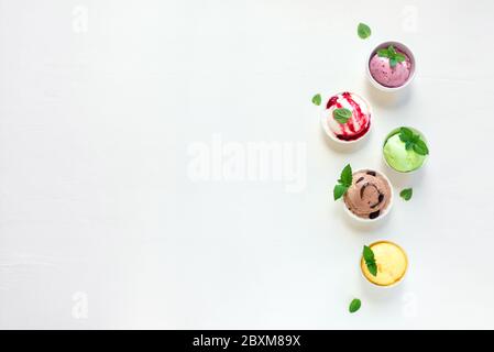 Eis-Set. Verschiedene italienische Eis auf weißem Hintergrund, Draufsicht, Kopierraum. Gefrorener Joghurt oder Eis-Sortiment in Tassen - gesunde Sommer d Stockfoto