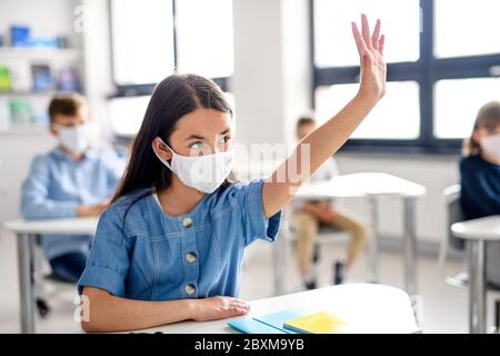 Mädchen mit Gesichtsmaske zurück in der Schule nach Covid-19 Quarantäne und Lockdown. Stockfoto