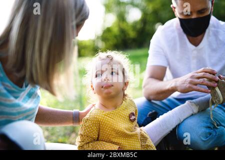 Familie mit kleiner Tochter auf Reise in die Natur, trägt Gesichtsmasken. Stockfoto