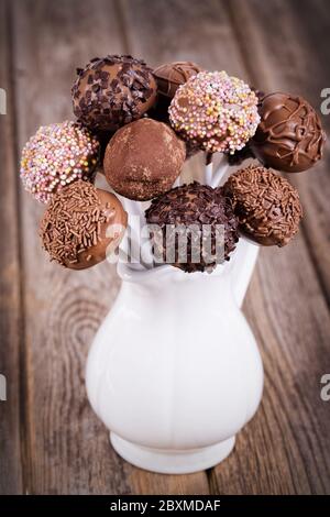 Hausgemachte Schokoladenkuchen knallt in einem weißen Krug. Vintage-Effekt auf alten Holztisch. Stockfoto