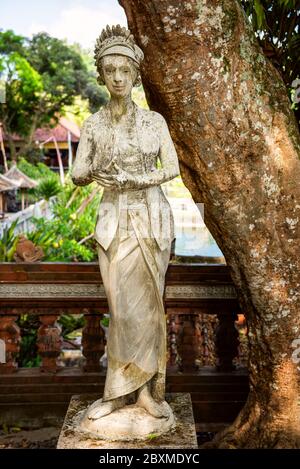 Dewi Sri oder Shridevi, die Reisgöttin. Steinfigur einer balinesischen Gottheit. Wasserpalast von Tirta Gangga in Ost-Bali, Indonesien. Steinstatue von Stockfoto